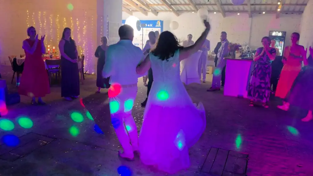 Ein glückliches Brautpaar zieht unter dem Applaus der Gäste und bunten Lichteffekten von einem Hochzeits DJ im Saarland auf die Tanzfläche ein.