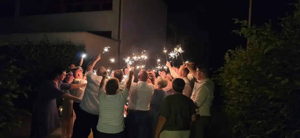Hochzeitsgäste bilden bei Nacht einen romantischen Spalier mit Wunderkerzen für das Brautpaar bei einer Hochzeitsfeier mit einem Hochzeits DJ im Saarland.